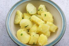 a bowl filled with cooked potatoes on top of a table