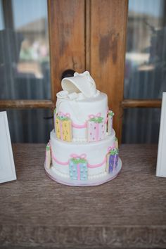 a three layer cake sitting on top of a wooden table