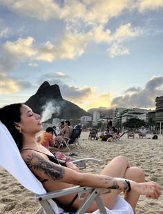 a woman sitting in a chair on the beach