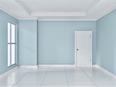 an empty room with blue walls and white floors