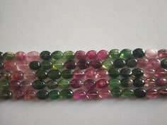 multicolored glass beads are lined up on a white surface