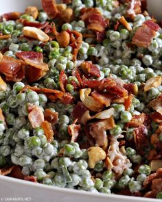 peas and bacon are mixed together in a white bowl with other food on the side