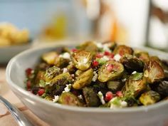 a white bowl filled with brussel sprouts and feta cheese