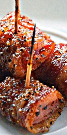 several pieces of meat with toothpicks sticking out of them on a white plate