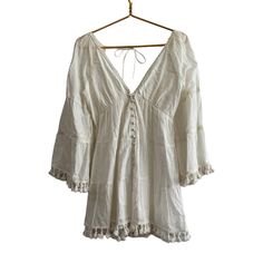 Alice + Olivia Alexandria Open Back Tunic Dress In Off-White. New With Tags - Several Small Flaws From Storage (Last 2 Pictures). I Have Not Tried To Remove. - 100% Cotton - Made In India - Fully Lined - Front Loop Button Closure - Smocked Back With Tie Closure - Kimono Sleeves With Tassel Fringe At Cuffs -Tassel Fringe At Hem - Tiered Voile Fabric With Lace Trim Throughout - Revolve Style No. Ali-Wd900 Approximate Measurements Laying Flat - Pit To Pit 16" Length Shoulder To Hem 31" Olivia White, Revolve Style, Voile Fabric, Kimono Sleeves, Kimono Sleeve, Tassel Fringe, Alice Olivia, Tunic Dress, Open Back