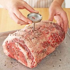 a person is using a meat thermometer to measure it on a piece of meat