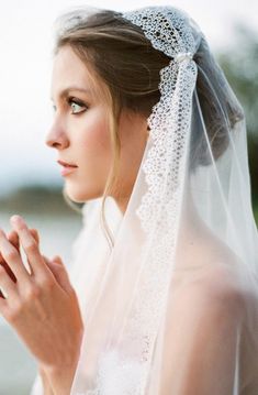 a woman wearing a veil and holding her hands together