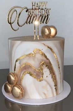 a white and gold birthday cake with the number 11 on top