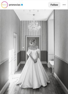 a woman in a wedding dress standing in a hallway