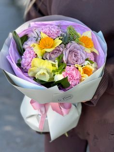 a woman holding a bouquet of flowers in her hands