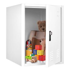 a teddy bear is sitting in a white cabinet with toys on the bottom and inside