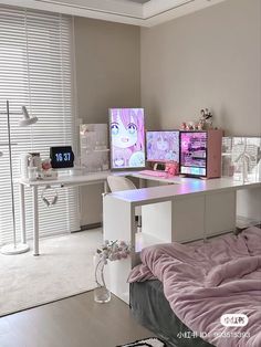 a bed room with a neatly made bed and two computer monitors on top of it