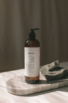 a bottle of soap sitting on top of a marble slab