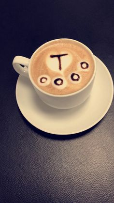 a cappuccino with the word pi in arabic written on it is sitting on a saucer