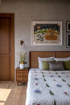 a bed sitting next to a wooden dresser in a bedroom under a painting on the wall