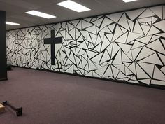 a room with a cross painted on the wall and broken pieces of paper all over the floor