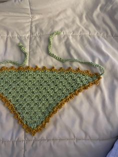 a crocheted triangle is laying on a bed