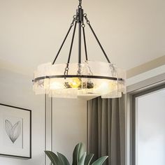 a potted plant sitting on top of a wooden table next to a light fixture