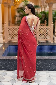 Gajjri pre-draped saree with mirror embroidery. Comes with a padded blouse and a petticoat.
Components: 3
Pattern: Embroidered
Type Of Work: Mirror
Neckline: Round
Sleeve Type: Sleeveless
Fabric: Semi crepe, Georgette, Chanderi, Lining: Semi crepe
Color: Red
Other Details: 
Attached lining
Product Weight: 1 Kg
Model Height: 5ft 9inches, wearing size S
Closure: Blouse - Back tie-up
Occasion: Sangeet - Aza Fashions Red Pre-draped Saree With Sheer Dupatta For Puja, Red Silk Saree With Mirror Work, Traditional Draped Lehenga With Mirror Work, Navratri Draped Traditional Wear With Mirror Work, Navratri Traditional Wear With Mirror Work And Draped Style, Navratri Traditional Wear With Mirror Work And Draped Shape, Festive Pre-draped Saree With Mirror Work For Puja, Navratri Traditional Wear With Mirror Work, Traditional Sleeveless Pre-draped Saree With Mirror Work