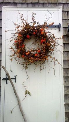 a door with a wreath on it and a tree branch hanging from the side of it