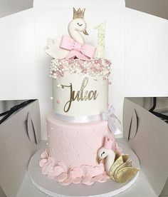 a pink and white cake with a bird on top