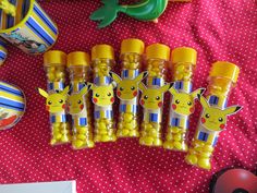 some yellow and blue candy sticks with pikachu faces on them sitting on a table