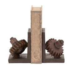 three wooden gears sitting on top of each other in front of a bookends