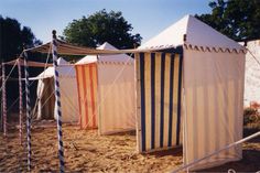 several tents are set up in the sand with ropes on each side and one tent is closed