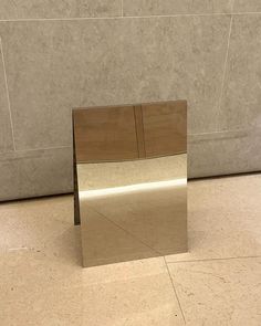 a mirror sitting on the floor in front of a wall