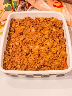 a casserole dish filled with meat and vegetables on top of a white table