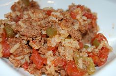 a white plate topped with rice covered in meat and veggies