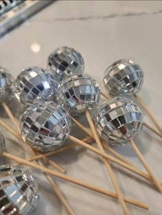 many shiny objects are sitting on top of wooden skewers with toothpicks sticking out of them