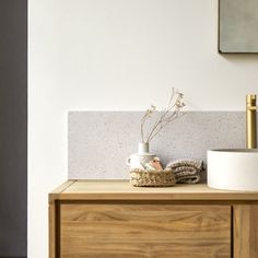 a white vase sitting on top of a wooden dresser