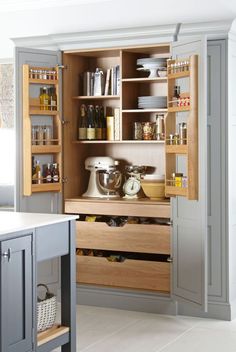 an open cabinet in a kitchen filled with appliances