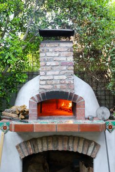 an outdoor brick oven with fire burning in it