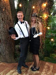 a man and woman are dressed up for a masquerade party in front of trees