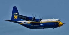 a blue and white airplane flying in the sky with propellers on it's wings