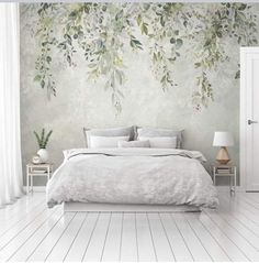 a bedroom with white floors and a large wall mural behind the bed is decorated with greenery