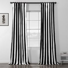 a black and white striped curtain hanging on a wall next to a window with a plant in the corner