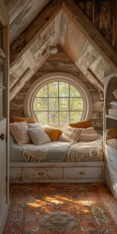 a bed sitting under a window in a room next to a rug on top of a wooden floor