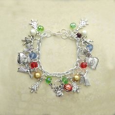 Christmas Charm Bracelet with Red, Blue and Crystal with Gold Pearl. Christmas Tree, Angel, Raindeer, Candy Cane and Santa Claus Charms on 7.5 Inch Silver Charm Bracelet. The bracelet contains Christmas Tree Charms Angel Charms Raindeer Charms Candy Cane Charms Santa Claus Charms Gold Faux Pearl Red Crystal Beads Blue Crystal Beads Green Crystal Beads on Silver 7.5 Inch Charm Bracelets Christmas bracelet red and green Christmas bracelet bead Christmas bracelet charms Christmas charm bracelet Multicolor Christmas Gift Bracelets, Multicolor Christmas Bracelet Jewelry, Multicolor Festive Bracelets For Christmas, Festive Multicolor Bracelets For Christmas, Adjustable Multicolor Christmas Jewelry, Christmas Festive Silver Charm Bracelet, Blue Christmas Jewelry For The Holidays, Blue Christmas Jewelry For The Holiday, Pearl Christmas Tree