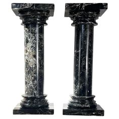 two black marble pedestals are shown against a white background