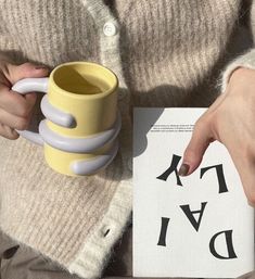 a person holding a yellow coffee mug over a piece of paper with the word diff written on it