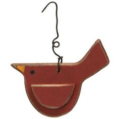 a red bird hanging from a hook on a white wall