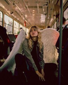 a woman sitting on the floor with an angel wings