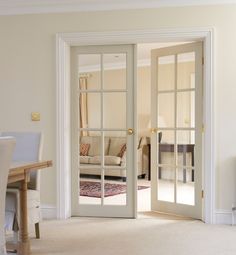 an open door leading to a living room with a couch and table in the background