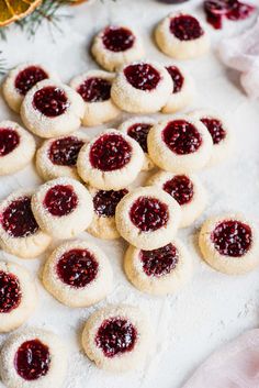 small cookies with jam on them sitting on a table