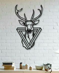 a deer head mounted to the side of a white brick wall next to a table