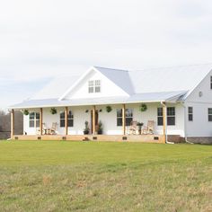 a large white house sitting on top of a lush green field