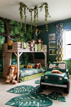 a child's bedroom decorated in green and white with jungle themed wallpapers